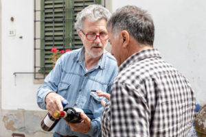 Men holding wine bottles in discussion, Florence, Italy Men holding wine bottles in discussion, Florence, Italy